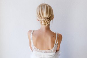Blonde woman in a white dress with a low bun wedding hairstyle